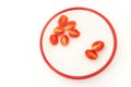 Six and two halves of red cherry tomatoes on white plate Royalty Free Stock Photo