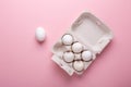 Six white eggs in carton box on pink paper background Top view Symbol Happy Easter Flat lay Royalty Free Stock Photo