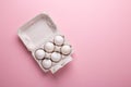 Six white eggs in carton box on pink paper background Top view Symbol Happy Easter Flat lay Royalty Free Stock Photo