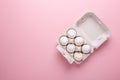 Six white eggs in carton box on pink paper background Top view Symbol Happy Easter Flat lay Royalty Free Stock Photo