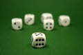 Six white game dice on a green background, shallow depth of field. The focus is on the nearest die Royalty Free Stock Photo