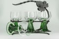 Six Wine Glasses With Green Stems sitting in a wrought iron rack