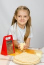 Six-year girl sitting at kitchen table in front of her are vegetables, base and other ingredients Royalty Free Stock Photo