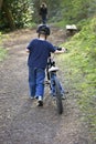 Six year old boy pushing a bike