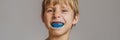 Six-year old boy shows myofunctional trainer. Helps equalize the growing teeth and correct bite, develop mouth breathing Royalty Free Stock Photo