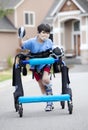 Six year old disabled boy in walker on street Royalty Free Stock Photo