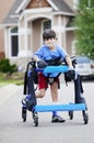 Six year old boy walking in walker down the street Royalty Free Stock Photo