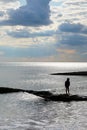 A six year old unrecognisable boy alone walking along a jetty in the sea Royalty Free Stock Photo