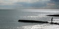 A six year old unrecognizable boy walking along a jetty in the sea Royalty Free Stock Photo