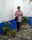 Sixty-three year old female Korean tourist posing with a coffee in Obidos, Portugal.