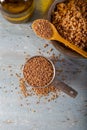 Siyez bulgur in metal measuring bowl on blue wooden table. Einkorn bulgur