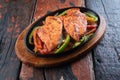 Sizzling chicken fillet with vegetables on rustic wooden table