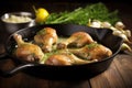 sizzling chicken legs in a pan with spluttering garlic butter