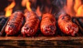 Sizzling Juicy Grilled Sausages Cooking Over Flaming BBQ Grill with Smoke and Fiery Background Royalty Free Stock Photo