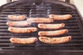 Sizzling smoking sausages cooking on a barbecue grill in New Zealand, NZ