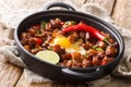 Sizzling spicy pork sisig with egg ang lime close-up in a pan. Horizontal Royalty Free Stock Photo