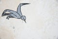 Skadovsk, Ukraine - June 15, 2017: Bird in flight, drawing on an old wall of whitewashed lime, background, retro drawing since uss
