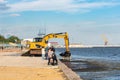 Skadovsk, Ukraine, June 08, 2021: Cleaning the beach from algae using an excavator