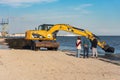Skadovsk, Ukraine, June 08, 2021: Cleaning the beach from algae using an excavator