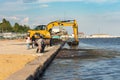 Skadovsk, Ukraine, June 08, 2021: Cleaning the beach from algae using an excavator