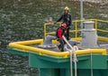 Two dock workers hauling ropes to secure cruise ship to bollards