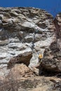 Skaha Bluffs Provincial Park, BC, Canada - March 13, 2022: Rock climber being spotted as they climb a cliff at a popular park