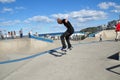 At the skate park near Sydney, Bondi Beach with the man in black jean and tee shirt showing his professional skateboard skill.