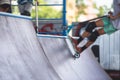 Skate park view with kids on a kick scooter doing tricks and stunts, boys in a skate park riding bmx bike and skate, playing and Royalty Free Stock Photo