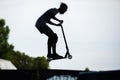 Skate park view with kids on a kick scooter doing tricks and stunts, boys in a skate park riding bmx bike and skate, playing and Royalty Free Stock Photo