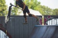 Skate park view with kids on a kick scooter doing tricks and stunts, boys in a skate park riding bmx bike and skate, playing and Royalty Free Stock Photo