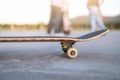 Skateboard in the foreground with skater kids talking in the background - Teen friends having fun skating - Extreme sport, Royalty Free Stock Photo