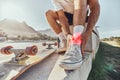 Skateboard man, injury and ankle pain, legs and outdoor accident, emergency or first aid risk with red glow at skatepark