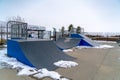 Skateboard ramps and melting snow on a skate park