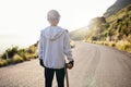 Skateboard, road and athlete doing training, exercise and fitness on a hill. Sun, man back and summer sport of a young Royalty Free Stock Photo