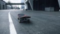 Skateboard rolling on asphalt. Black skate conceptual for street sports.