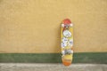 Skateboard on yellow and green wall