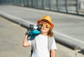 Skateboarder child boy in skate park. Kid boy with skateboard. Childhood, leasure, lifestyle concept. Portrait stylish