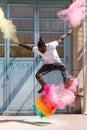 Skateboarder doing kickflip with colorful holi powder Royalty Free Stock Photo