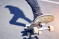 Skateboarder doing a trick in a skate park, close-up old skateboard. Royalty Free Stock Photo