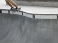 Skateboarder Grinding a Rail on the Edge of a Bowl Pool at a Skate Park Royalty Free Stock Photo