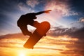 Skateboarder jumping at sunset.