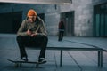 skateboarder in modern streetwear sitting on bench