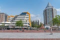 Skateboarder passes through urban open public space with tall apartment building next to architecturally district Central Library