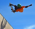 Skateboarder performing grab stunt on Vert Ramp. Royalty Free Stock Photo