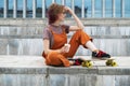 Skateboarder young woman resting drinking coffee to go.