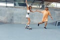 Skateboarding. Couple In Casual Outfit Riding On Skateboard At Skatepark