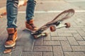 Skateboarding. A man in brown sneakers put his foot on a skateboard. Close up