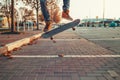 Skateboarding. A man does an Ollie stunt on a skateboard. Board in the air. Close-up of legs. Street on the background