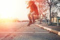 Skateboarding. A man does an Ollie stunt on a skateboard. Jump in the air. Street on the background. Sunlight