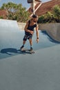 Skateboarding. Man In Urban Outfit Riding On Skateboard On Concrete Ramp At Skatepark Royalty Free Stock Photo